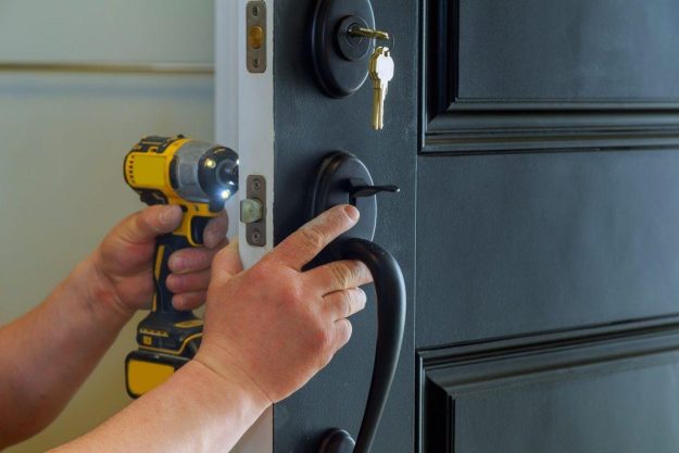 closeup-of-a-professional-locksmith-installing-a-new-lock-on-a-house-exterior-door-with-the-inside.jpg